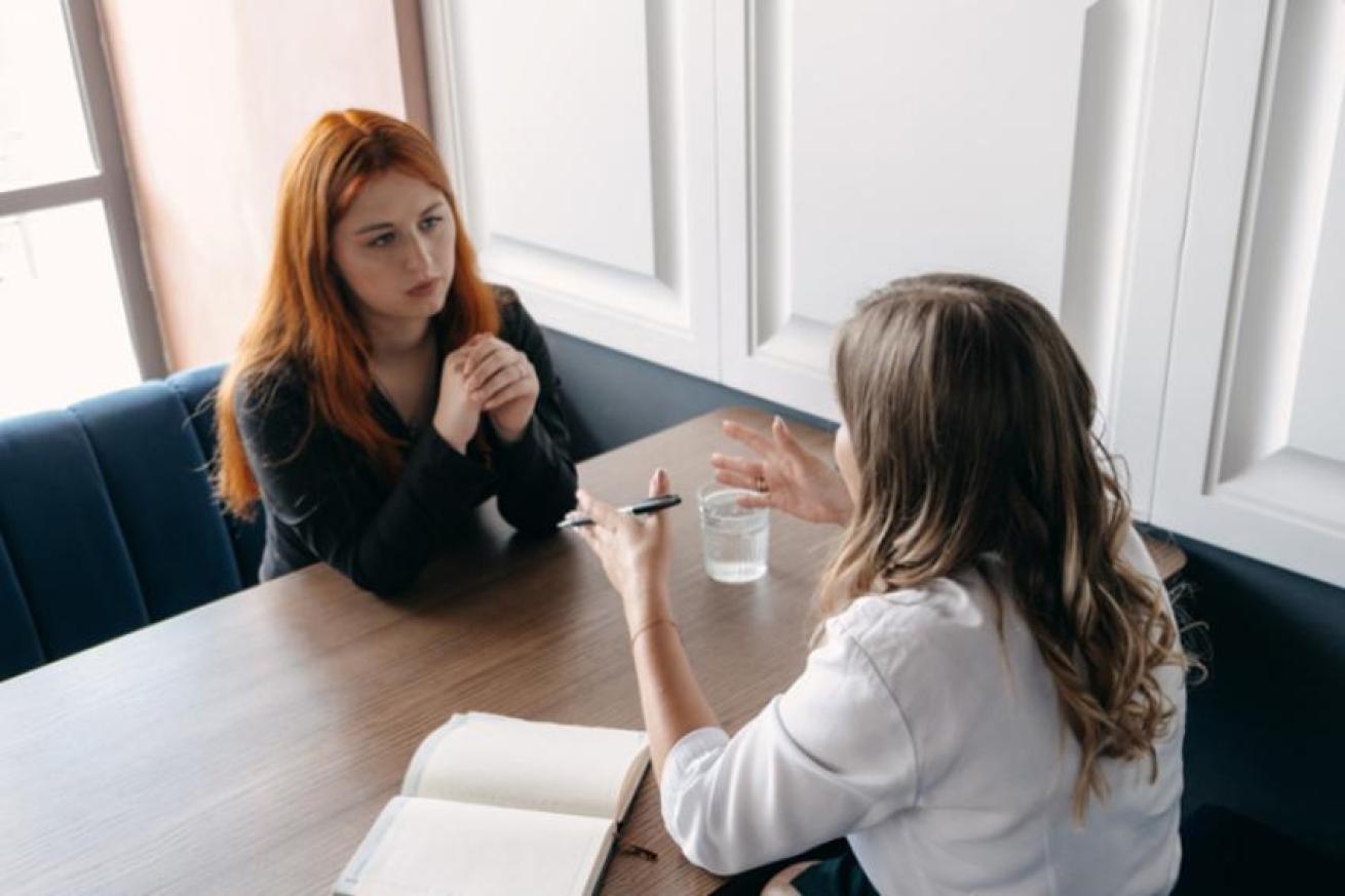 Photo showing two women talking together at a table