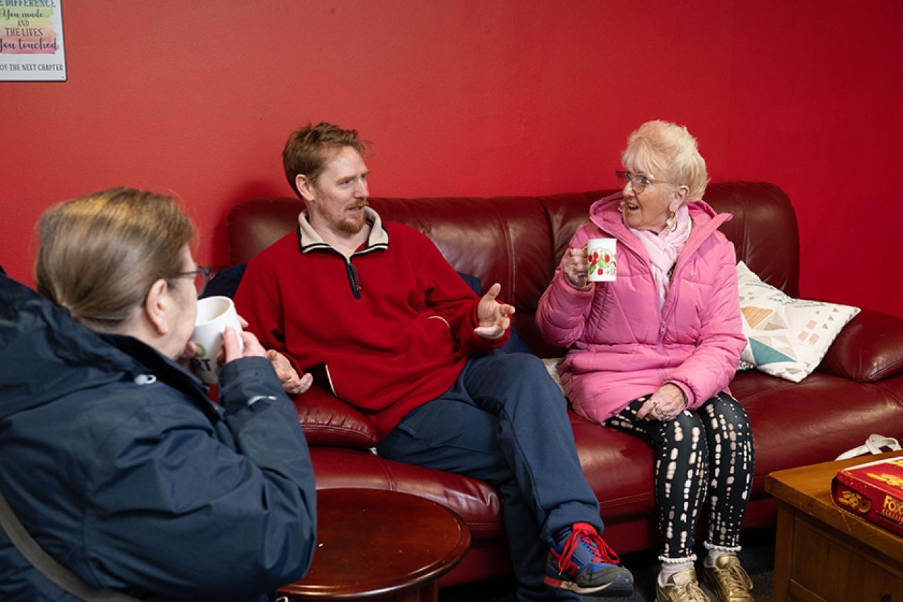 Sanctuary residents sat on a sofa while meeting their housing officers